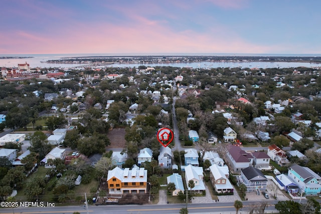 aerial view at dusk featuring a water view