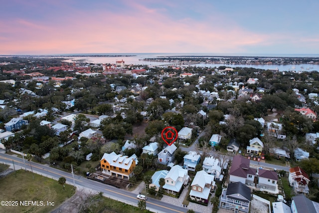 aerial view at dusk featuring a water view