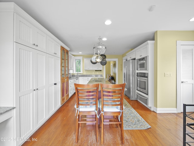 kitchen featuring white cabinets, sink, stainless steel appliances, and light hardwood / wood-style flooring