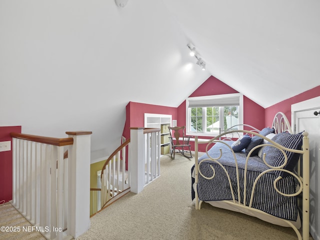 carpeted bedroom featuring rail lighting and lofted ceiling