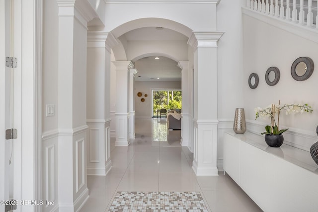 hallway with ornate columns and light tile patterned flooring