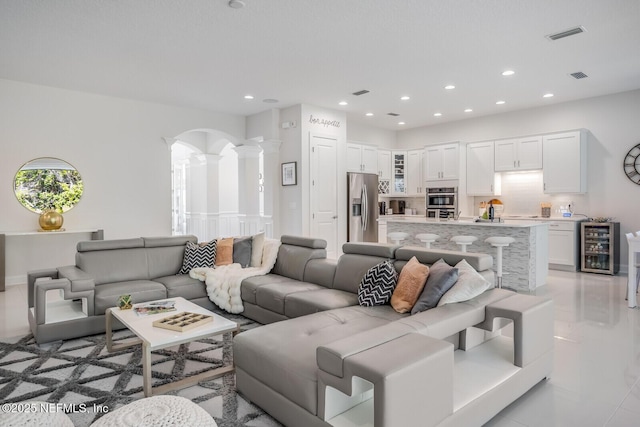 tiled living room with ornate columns and beverage cooler