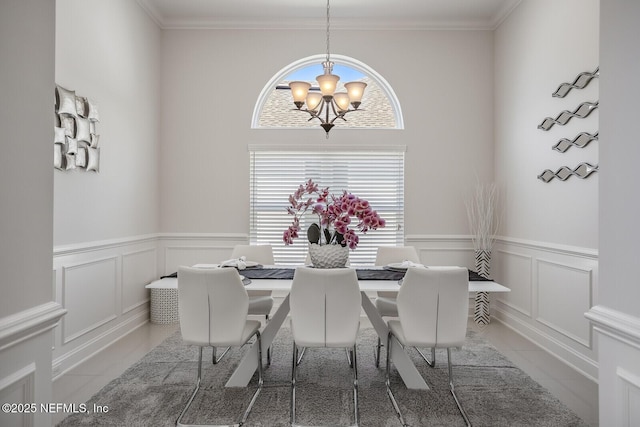 tiled dining room with ornamental molding and a notable chandelier