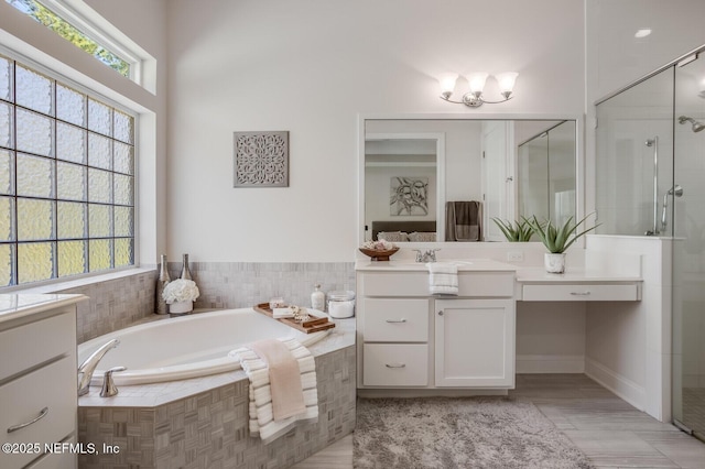 bathroom with vanity and shower with separate bathtub