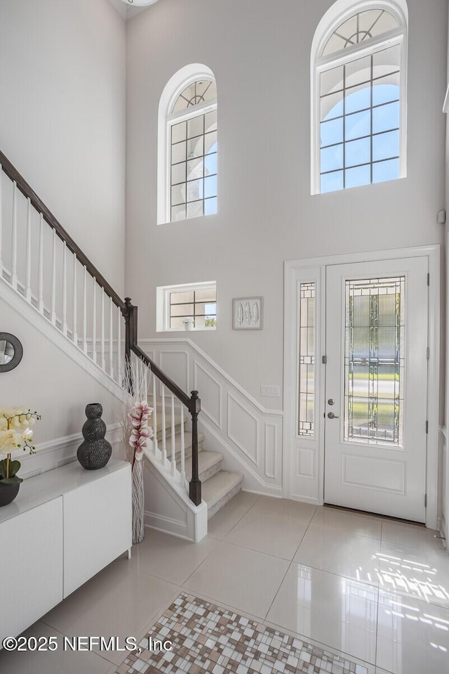 tiled entrance foyer featuring a high ceiling