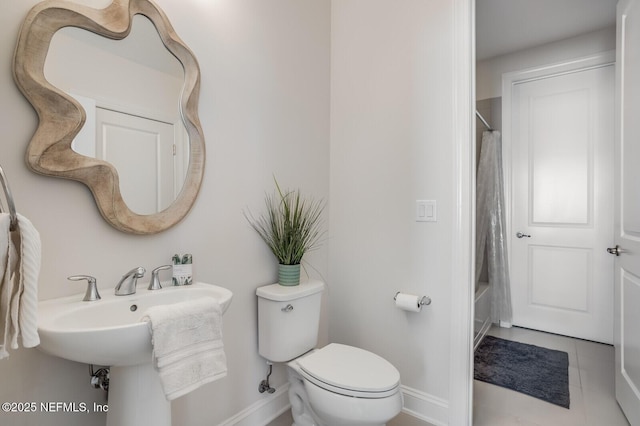 bathroom with tile patterned floors, toilet, and shower / bath combo with shower curtain