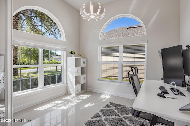 office area featuring light tile patterned flooring, a notable chandelier, and a wealth of natural light