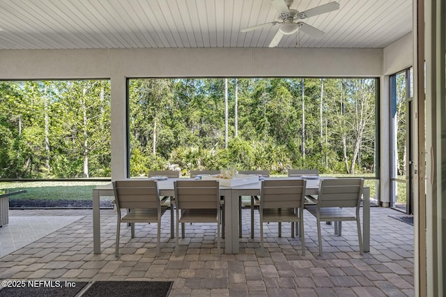 unfurnished sunroom with ceiling fan