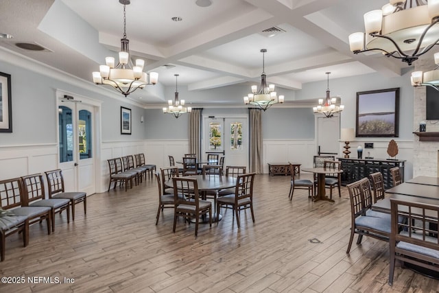 dining room featuring beam ceiling, coffered ceiling, a notable chandelier, light hardwood / wood-style floors, and french doors