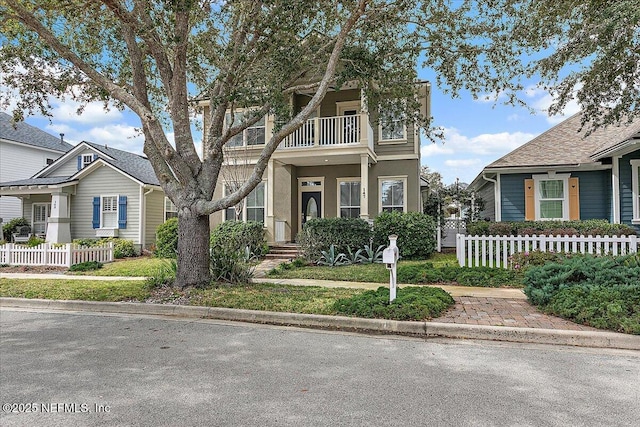 view of front facade featuring fence and a balcony