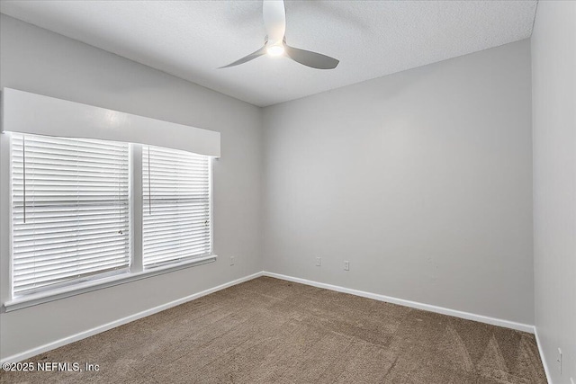 unfurnished room featuring a textured ceiling, carpet, a ceiling fan, and baseboards