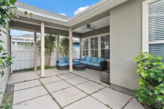 view of patio / terrace with an outdoor living space, fence, and a ceiling fan