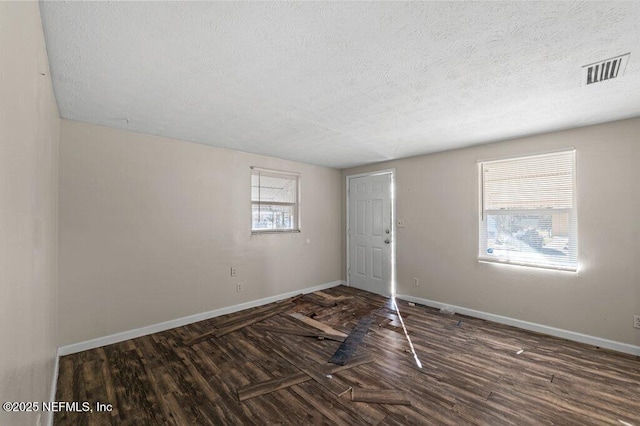 spare room with dark hardwood / wood-style flooring and a textured ceiling