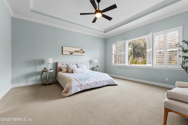 bedroom with multiple windows, ornamental molding, carpet flooring, and a tray ceiling