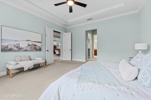 carpeted bedroom featuring connected bathroom, ornamental molding, a raised ceiling, and ceiling fan