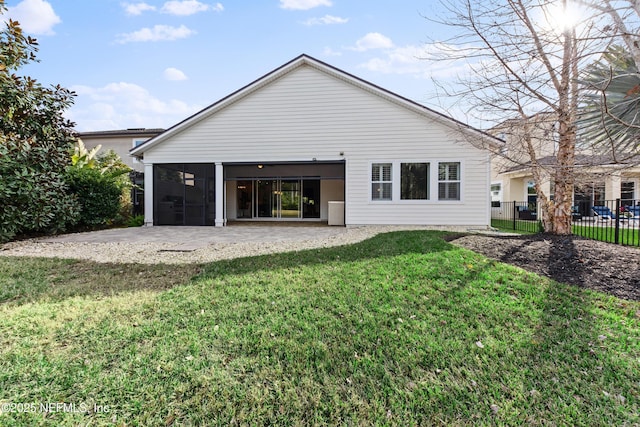 back of house featuring a yard, a sunroom, and a patio