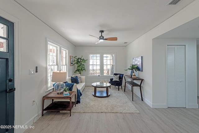 living room with ceiling fan and light hardwood / wood-style flooring