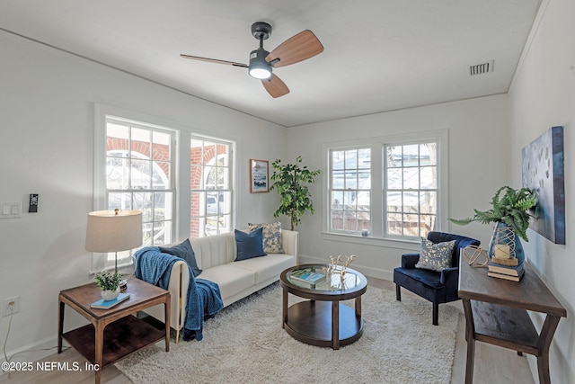 living room with ceiling fan, crown molding, and hardwood / wood-style flooring