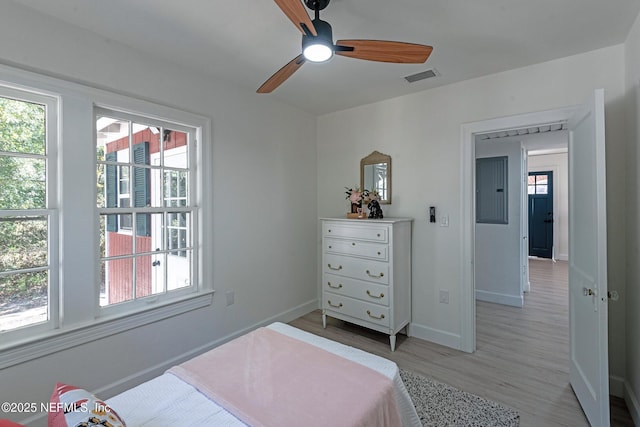 bedroom featuring ceiling fan, electric panel, and light wood-type flooring