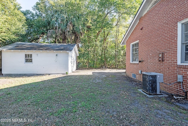 view of yard with central AC and an outdoor structure