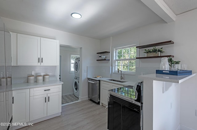 kitchen featuring sink, white cabinetry, stacked washer / dryer, stainless steel dishwasher, and backsplash