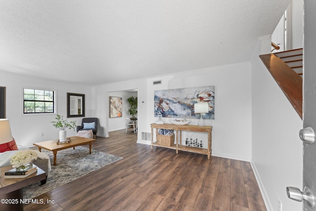 living room with dark hardwood / wood-style floors and a textured ceiling