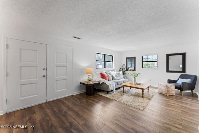 living room featuring a textured ceiling and dark hardwood / wood-style floors