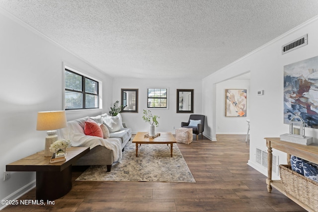 living room featuring dark hardwood / wood-style flooring, a textured ceiling, and ornamental molding