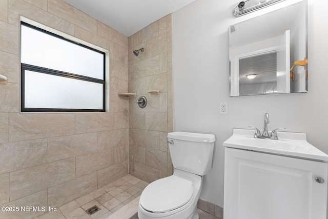 bathroom featuring toilet, vanity, and tiled shower