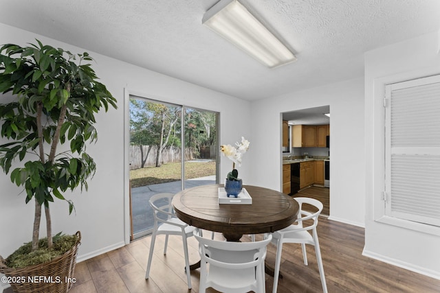 dining room with a textured ceiling and hardwood / wood-style flooring