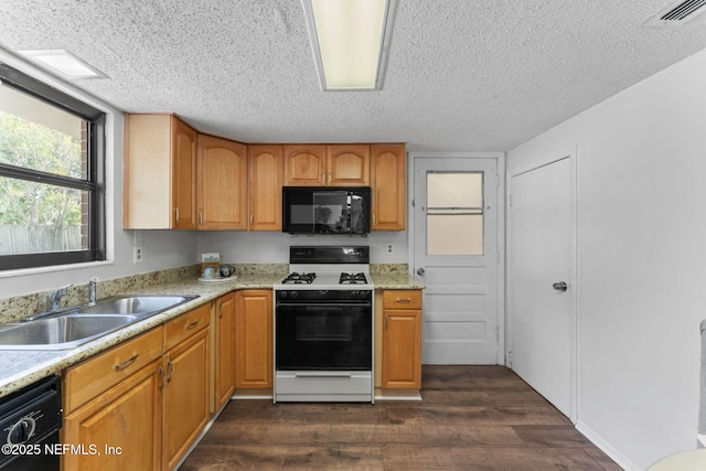 kitchen with black appliances, sink, dark wood-type flooring, a textured ceiling, and light stone counters