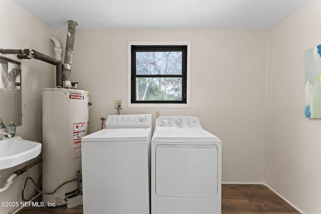 clothes washing area featuring dark hardwood / wood-style flooring, washer and clothes dryer, and gas water heater