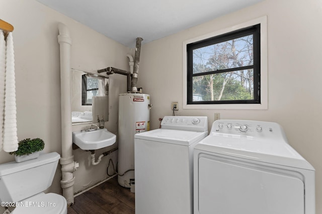 laundry area featuring sink, water heater, dark hardwood / wood-style floors, and independent washer and dryer