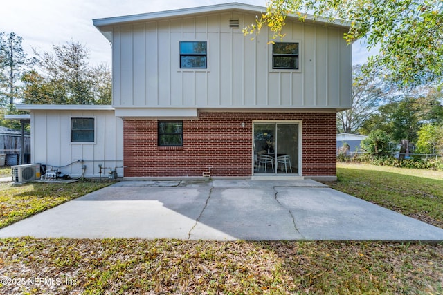 rear view of property featuring ac unit, a lawn, and a patio