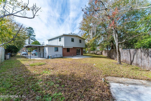 rear view of house with a lawn, a patio area, and a carport