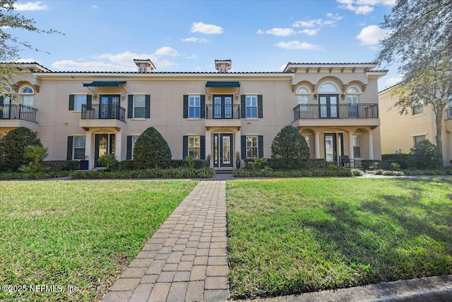 mediterranean / spanish home featuring a front lawn