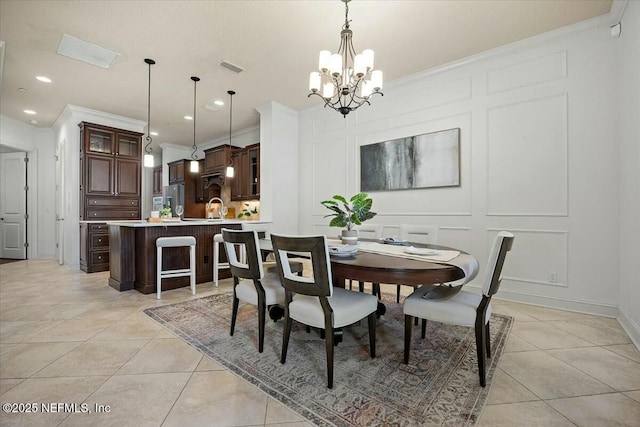 dining space featuring crown molding, sink, light tile patterned floors, and an inviting chandelier