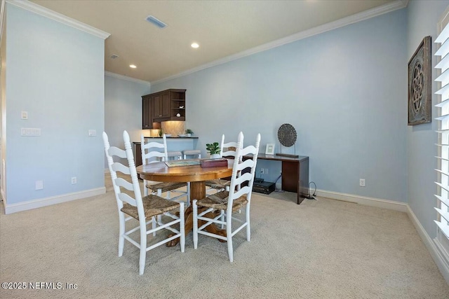 carpeted dining room featuring crown molding