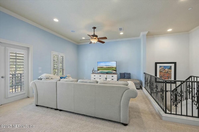 living room with crown molding, light colored carpet, and ceiling fan