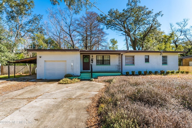 ranch-style house with a carport, covered porch, and a garage