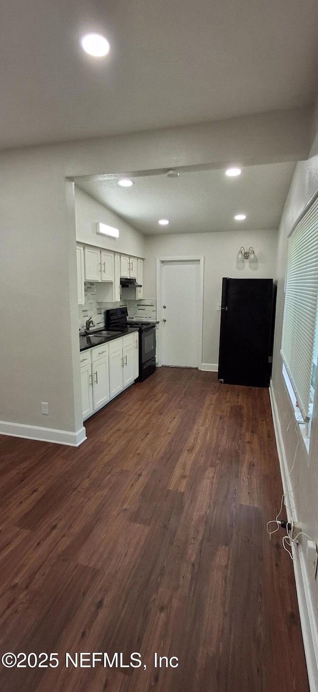 kitchen with backsplash, black electric range, sink, white cabinetry, and dark hardwood / wood-style flooring