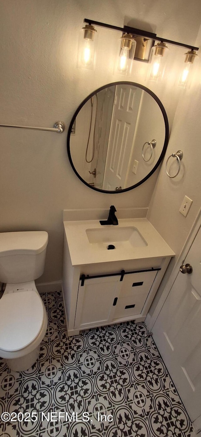 bathroom featuring toilet, tile patterned floors, and vanity