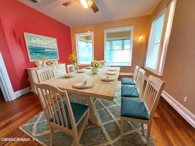 dining area featuring dark wood-type flooring and ceiling fan