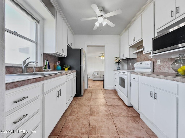 kitchen featuring white appliances, sink, and white cabinets