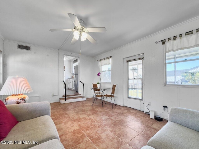 living room with light tile patterned flooring, ceiling fan, and ornamental molding