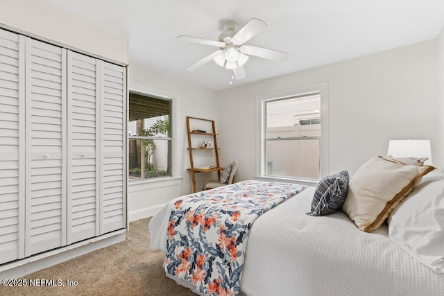 carpeted bedroom featuring baseboards, a ceiling fan, and a closet