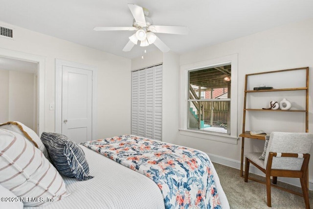 carpeted bedroom with a ceiling fan, baseboards, visible vents, and a closet