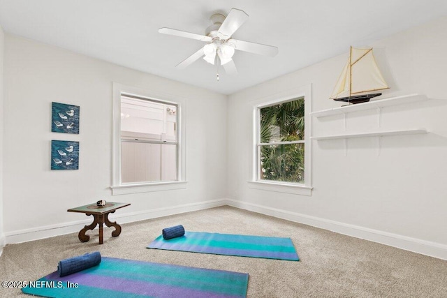 exercise room featuring a ceiling fan, baseboards, and carpet flooring