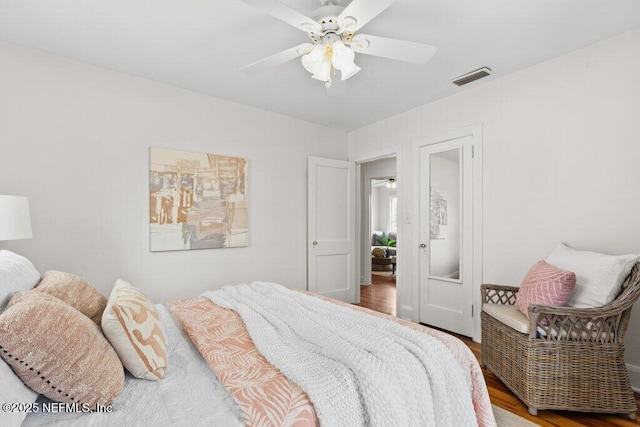 bedroom featuring visible vents, ceiling fan, and wood finished floors