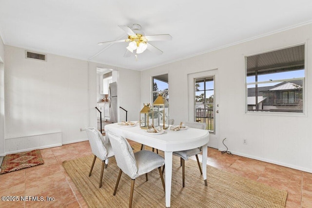 dining space with ornamental molding, visible vents, ceiling fan, and baseboards